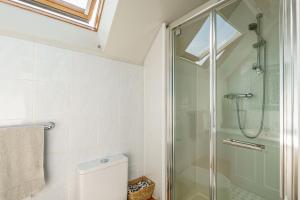 a bathroom with a toilet and a glass shower at The Cheeseloft - Spacious one bed with terrace in Kirkcudbright