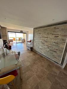 a living room with a large brick wall at OCEAN VIEW, Prestigia Plage des Nations in Sidi Bouqnadel