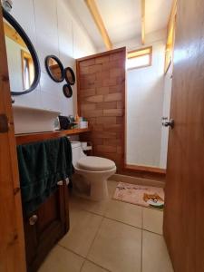 ein Badezimmer mit einem WC, einem Waschbecken und einem Spiegel in der Unterkunft Pichidangui Comoda Casa Vista al Mar Full Equipada in Pichidangui