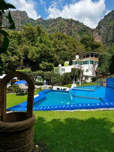 una piscina frente a una casa con montaña en BUNGALOWS ANDREA, en Tepoztlán