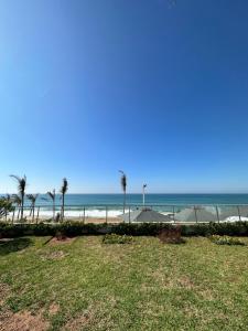 a view of the beach with palm trees and umbrellas at OCEAN VIEW, Prestigia Plage des Nations in Sidi Bouqnadel