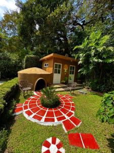 una pequeña casa con un jardín decorado en rojo y blanco en BUNGALOWS ANDREA, en Tepoztlán