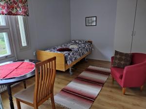a bedroom with a bed and a table and a chair at Saarnimaja in Hämeenlinna