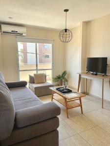 a living room with a couch and a tv at Complejo Hermogenes in San Juan