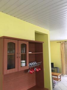 a room with a cabinet with red pots and pans at Hinarani Home Haapiti in Haapiti