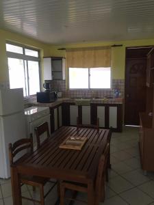 a kitchen with a wooden table with chairs and a table sidx sidx sidx at Hinarani Home Haapiti in Haapiti