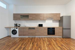 a kitchen with wooden cabinets and a washer and dryer at T&K Apartments - Duisburg - 3 and 4 Room Monteur Apartments in Duisburg