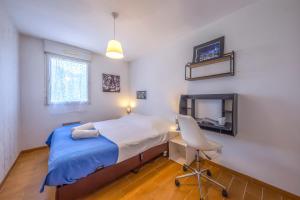 a bedroom with a bed and a desk and a chair at L'Espace Détente - GEM / GARE in Grenoble