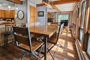 a dining room with a wooden table and a clock on the wall at Artist's Cove in Manitowish Waters