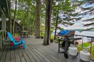einen Grill auf einer Terrasse mit einem Tisch und Stühlen in der Unterkunft Artist's Cove in Manitowish Waters