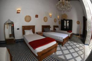 um quarto com duas camas e um espelho em hostel Dar belghiti em Fez