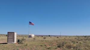 Pinta的住宿－Painted Desert Wellness Retreat，一块在田野中间悬挂的美国国旗