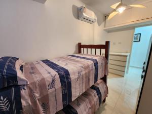 um quarto com uma cama com um cobertor em Lindo apartamento3 quartos Enseada 8 pessoas no Guarujá