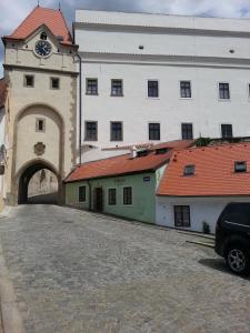 un gran edificio con una torre de reloj junto a una calle en Penzion U Tomáše en Jindrichuv Hradec