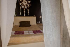 a small bedroom with a bed and a chandelier at Casa Jasmin Bed & Breakfast in Troncones