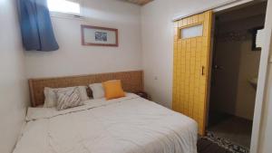 a bedroom with a bed and a yellow door at BigBlue Surf Experience Hostel in Taghazout