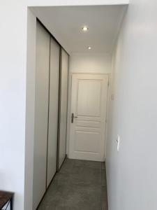 korytarz z białymi drzwiami i podłogą wyłożoną kafelkami w obiekcie Chambre Maxilly w mieście Maxilly-sur-Léman