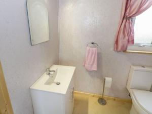 ein Bad mit einem Waschbecken, einem WC und einem rosa Handtuch in der Unterkunft The Lazy Llama Farm Stay Shepherd Hut in Ballyshannon