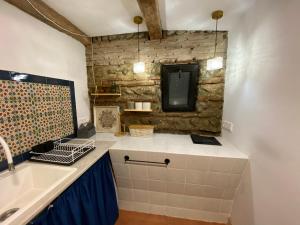 una cucina con lavandino e parete in pietra di Terracotta a Telavi