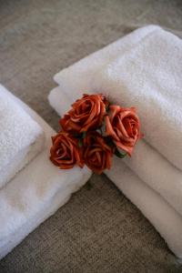 un fiore che poggia su asciugamani bianchi di Spacious 3 bedroom apartment free parking! a Kent