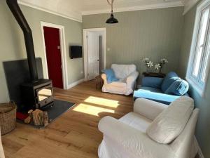 a living room with a couch and a fire place at Lower Hill Cottage w/Swedish Hot Tub in Bodmin