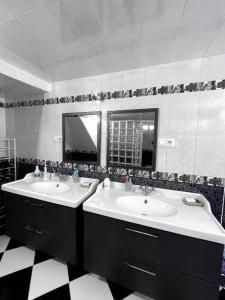łazienka z 2 umywalkami i podłogą wyłożoną szachownicą w obiekcie Traditional Riad in Rabat w mieście Rabat