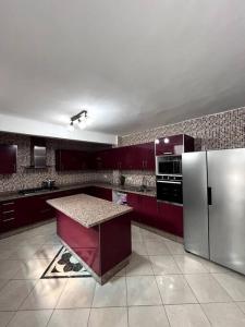 a kitchen with red cabinets and a refrigerator at Traditional Riad in Rabat in Rabat