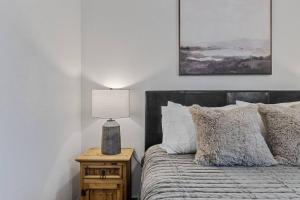 una camera da letto con un letto con una lampada sul comodino di 5th St Getaway w Sauna Hot tub Firepit & Game Room a Waco