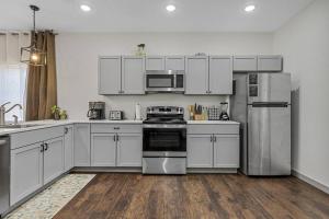 a kitchen with white cabinets and stainless steel appliances at 5th St Getaway w Sauna Hot tub Firepit & Game Room in Waco