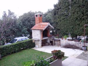 a dog house with a brick chimney on a yard at Apartments Pero in Kožino