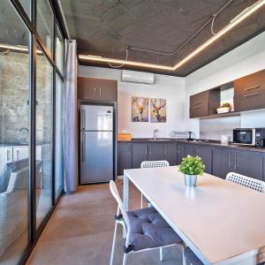 uma cozinha com uma grande mesa branca e cadeiras em Trendy house -deadsea em Al Rama
