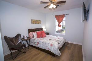 a bedroom with a bed and a chair and a window at Elegant 3 bedroom apt with free parking and balcony in Nashville