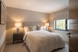 1 dormitorio con 1 cama con 2 lámparas y una ventana en The Orchard, 5 Star Luxury Accommodation, en Newcastle