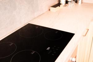 un bancone da cucina con un piano cottura nero di Ghiberti Boutique Apartment a Firenze Altre 8 foto