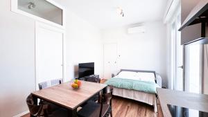 Ghiberti Boutique Apartment في فلورنسا: غرفة نوم بسرير وطاولة خشبية مع صالة طعام