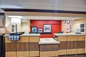 a lobby of a hospital with red walls and counters at Hampton Inn Albany-Wolf Road in Albany
