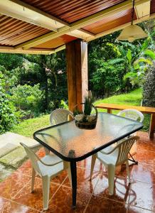 een glazen tafel en stoelen op een patio bij Luxurious private room with bathroom in mountaine in Sorá