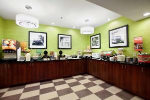 un mostrador de comida en un restaurante con paredes verdes en Hampton Inn Atlanta-Stockbridge en Stockbridge