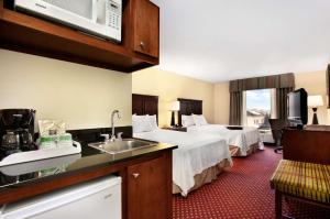 a hotel room with a bed and a kitchen with a sink at Hampton Inn Atlanta-Stockbridge in Stockbridge