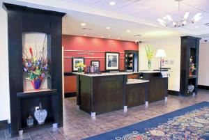 a lobby with a counter with flowers on it at Hampton Inn Orange in Orange
