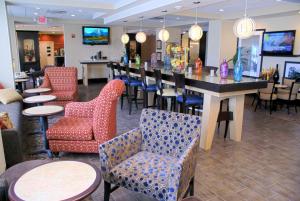 a bar in a restaurant with chairs and tables at Hampton Inn Orange in Orange