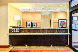 a hotel lobby with a reception counter and a mirror at Hampton Inn & Suites Atlanta-Galleria in Atlanta