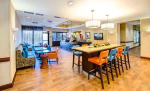 a kitchen and living room with a bar and chairs at Hampton Inn & Suites Atlanta-Galleria in Atlanta