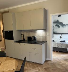 a kitchen with white cabinets and a bed at Luna Apartment in Warsaw