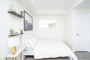 um quarto branco com uma cama e uma secretária em Beautiful Luxurious Modern Condo With Breathtaking Views em Toronto
