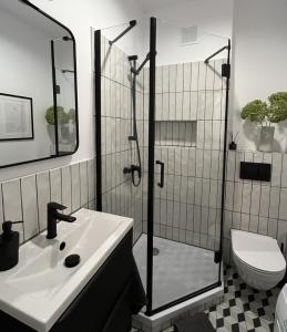 een badkamer met een douche, een wastafel en een toilet bij Luna Apartment in Warschau