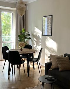 sala de estar con mesa, sillas y sofá en Luna Apartment, en Varsovia