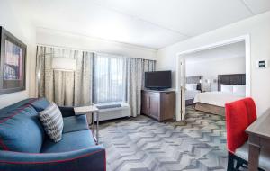 Pokój hotelowy z kanapą, łóżkiem i telewizorem w obiekcie Hampton Inn & Suites Atlanta-Galleria w Atlancie