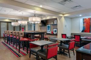 a restaurant with tables and chairs and a bar at Hampton Inn Atlanta McDonough in McDonough