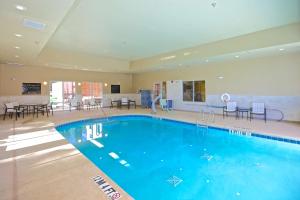 a large swimming pool in a hotel with tables and chairs at Hampton Inn Atlanta McDonough in McDonough